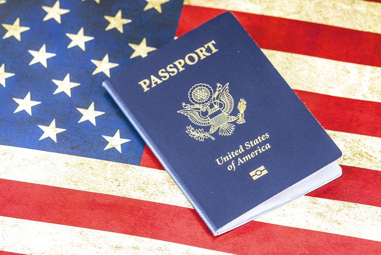 An image of the US flag and passport, representing that many Indians are willing to shift to this country