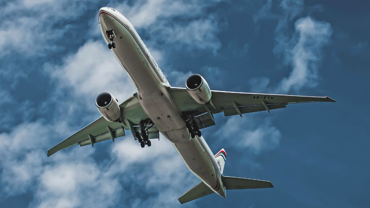 A commercial airplane taking off against a blue sky, representing flight travel.